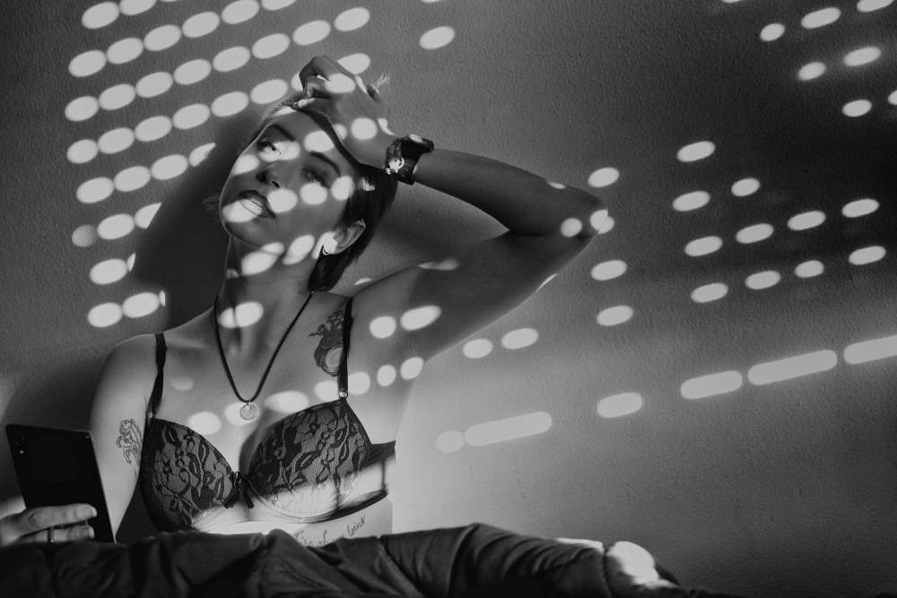 A woman wearing a bra in the shadows