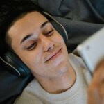 a viewer watching a cam girls performance with a tablet and headphones