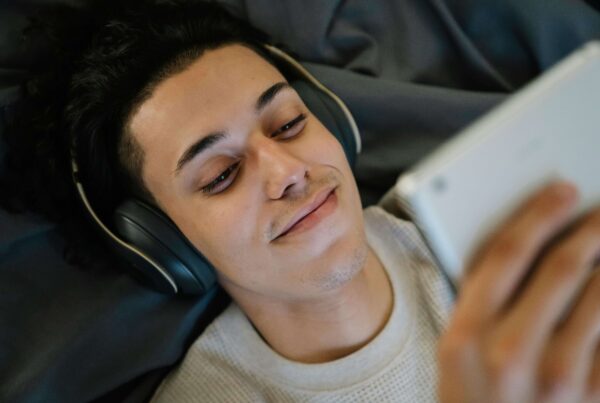 a viewer watching a cam girls performance with a tablet and headphones