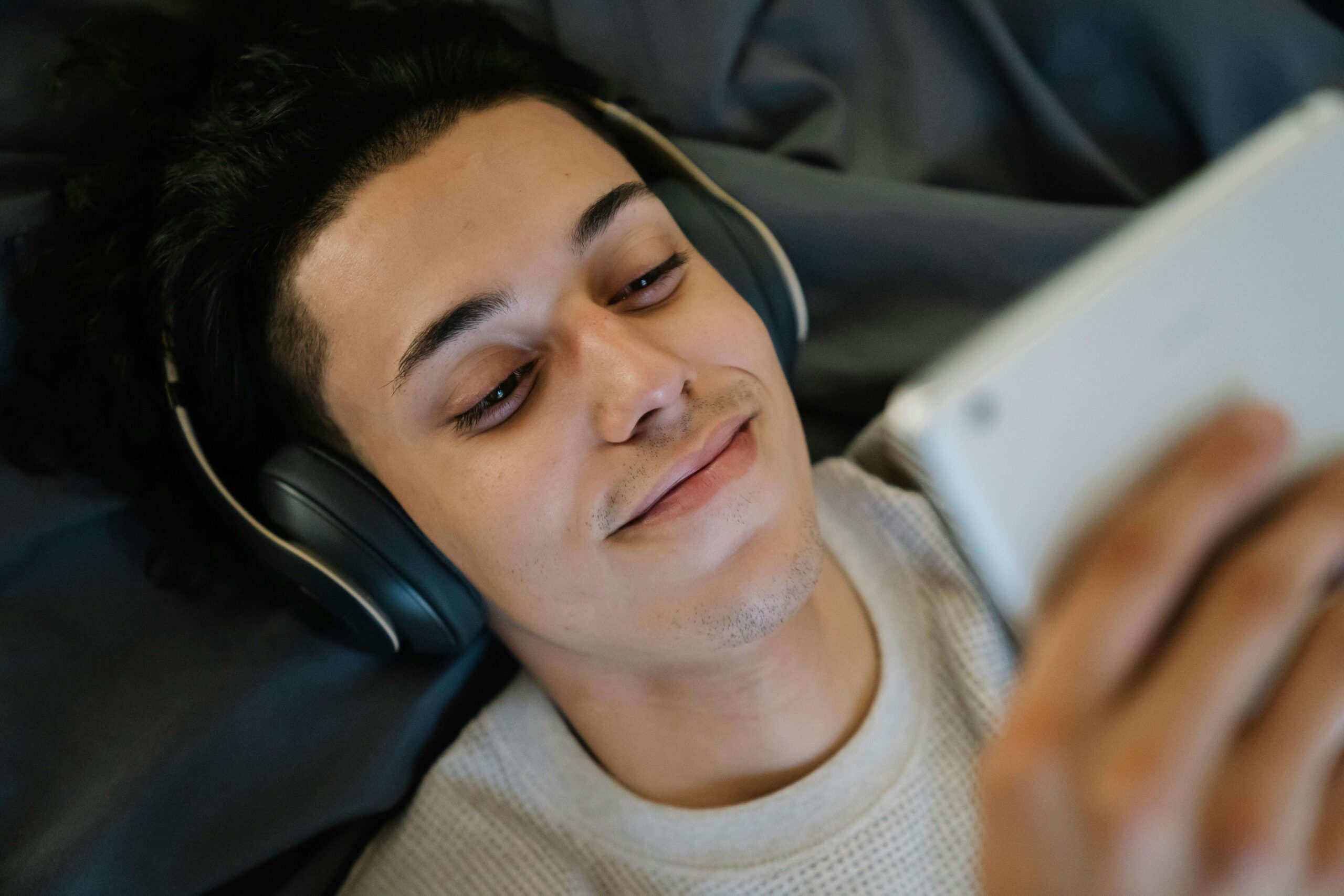 a viewer watching a cam girls performance with a tablet and headphones
